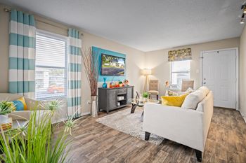 roomy living room with ample natural light and plank flooring at 701 South Apartments in Mobile, AL